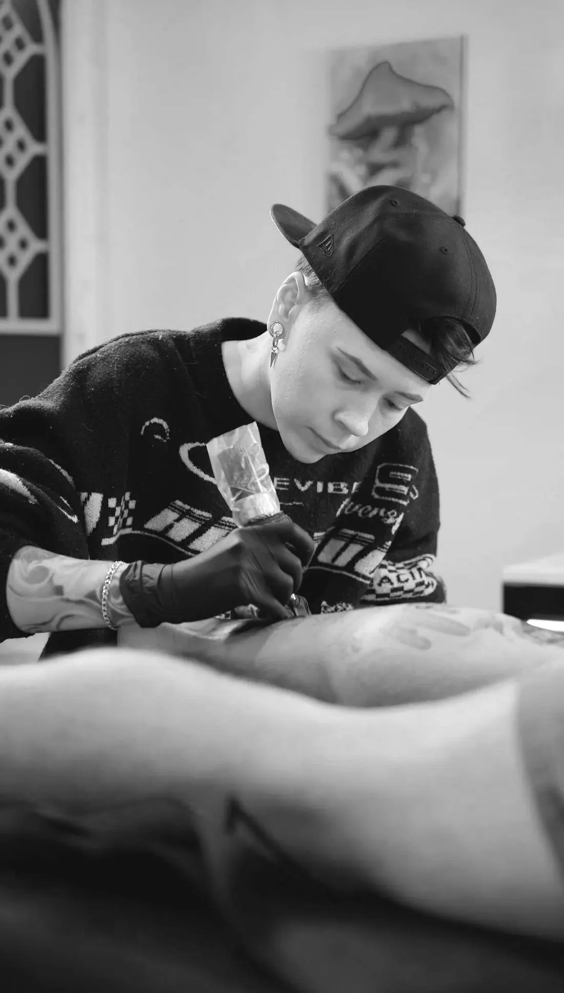 Kris Barnas tattooing a client in the studio