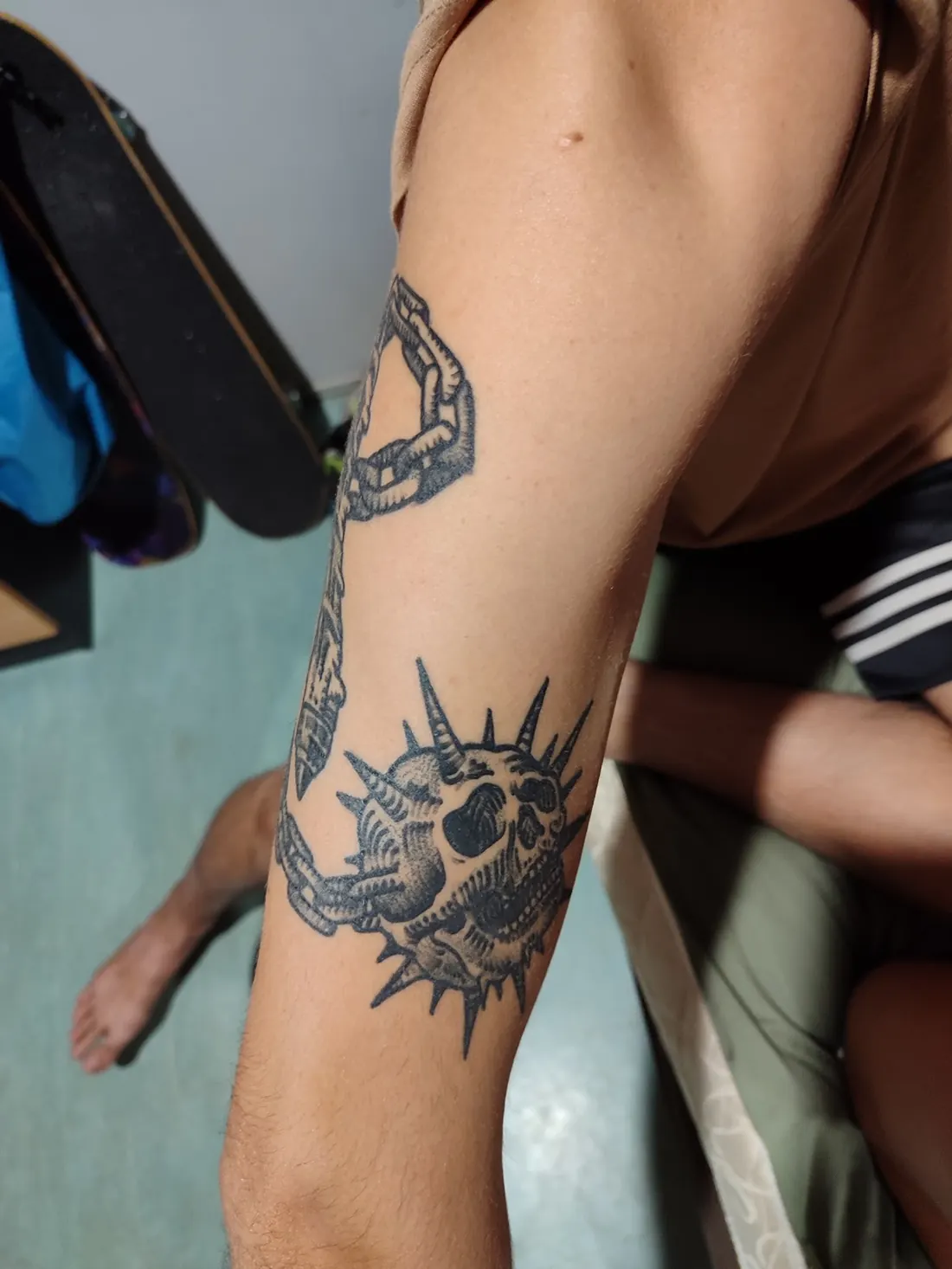 Spiked skull tattoo with chain detailing
